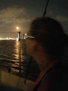 Barb looking at the moon rise while navigating up the Delaware River